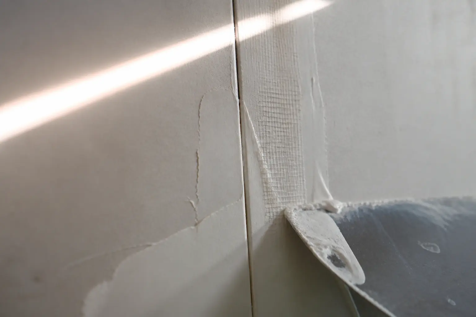 Bande a joint placo sur joint de plaques BA13, avec bande intégrée au mastic et fissure légère à côté
